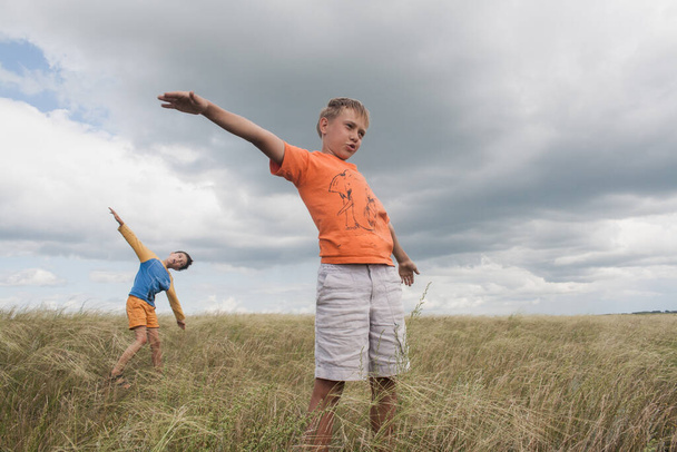 boys standing in a field . Boys in shorts.   two friends. children playing in the field. - Valokuva, kuva
