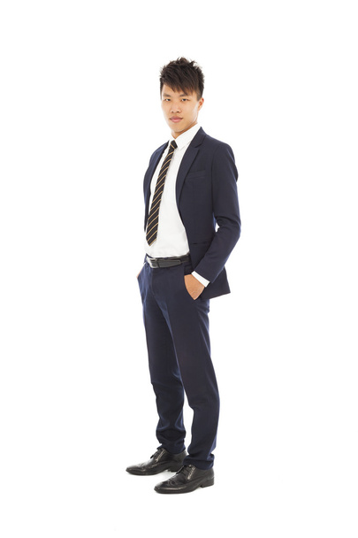 handsome businessman standing and hands in his pockets - 写真・画像