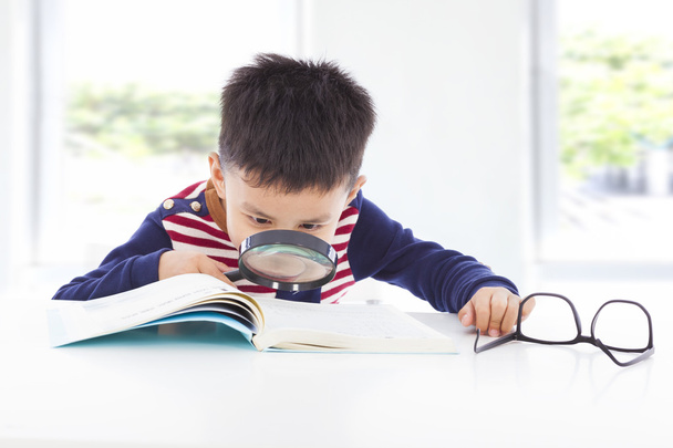 маленький хлопчик детектив шукає підказки з книг
 - Фото, зображення