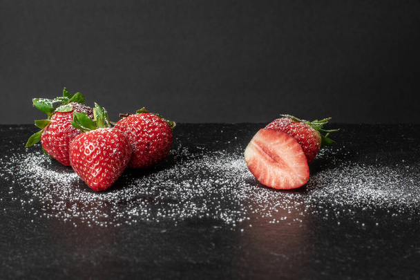 A closeup shot of fresh strawberries on dark bacxkground - Fotografie, Obrázek
