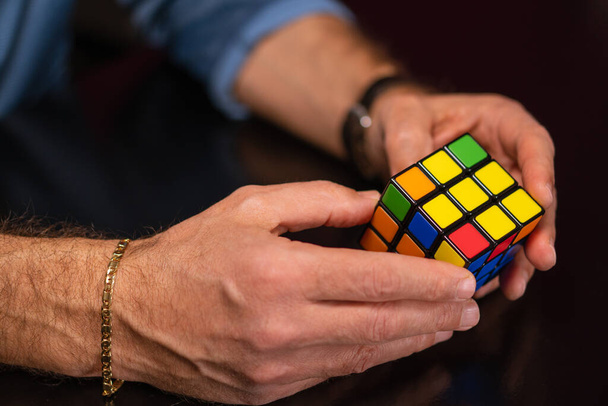 SANTA MARIA CAPUA VETERE, ITÁLIE - Únor 01, 2021: Caserta, Itálie, 31. ledna 2021, Rubikova krychle v rukou se zavírá. Vynalezl ji maďarský architekt Erno Rubik v roce 1974. - Fotografie, Obrázek