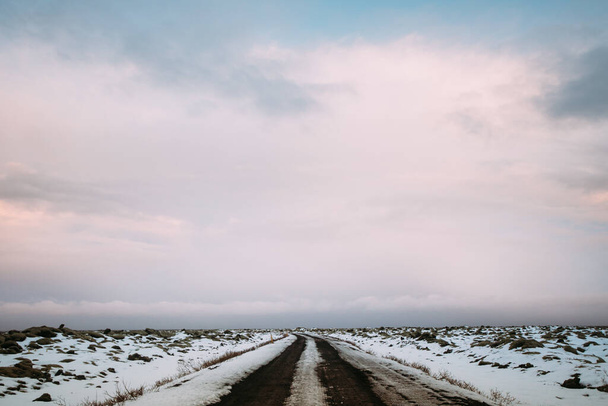 A closeup shot of an empty road surrounded by snowy landscapes - Zdjęcie, obraz