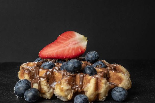 A closeup shot of homemade Belgian waffles with strawberries and blueberries - Photo, Image