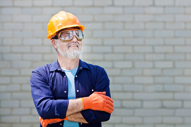 Portrait of happy seniorman with hard hat Posing with crossed ar - Foto, immagini