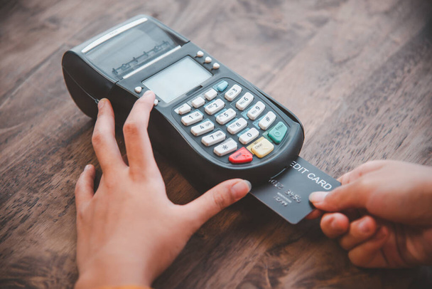 Bezahlen mit Kreditkarte, Kauf und Verkauf von Produkten mit einem Kreditkartenstreifautomaten - Foto, Bild