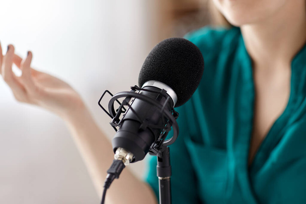 woman with microphone recording podcast at studio - Φωτογραφία, εικόνα