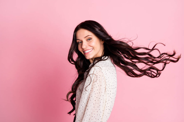 Photo portrait of girl wearing white dotted blouse laughing cheerful with flying hair isolated on pastel pink color background copyspace - Photo, image