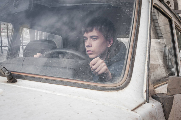 boy driving a car . boy sitting in front of the car holding steering wheel. - Valokuva, kuva