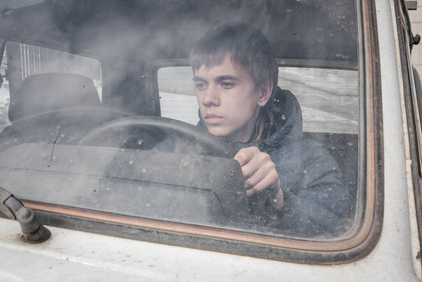 boy driving a car . boy sitting in front of the car holding steering wheel. - Foto, Bild