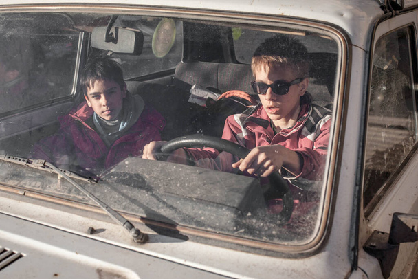 boy driving a car. boy sitting in front of the car holding steering wheel. - Fotografie, Obrázek