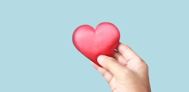 Manos sosteniendo un corazón rojo. conceptos de donación de salud cardíaca - Foto, Imagen