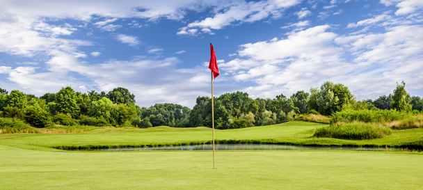 Mettre du vert avec un drapeau sur un terrain de golf un jour d'été - Photo, image