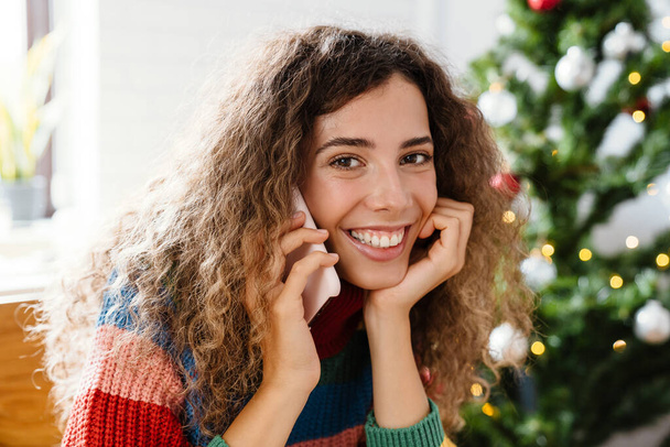 Happy charming woman talking on mobile phone and smiling at home - Photo, Image