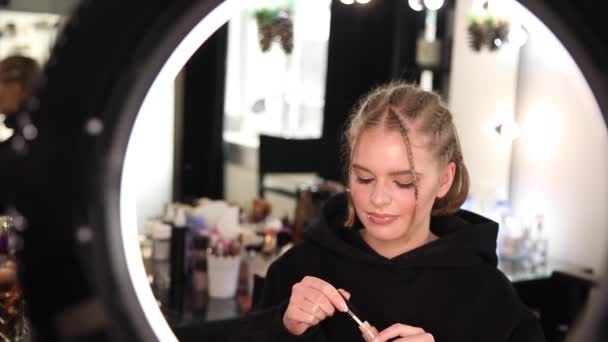 Όμορφη ξανθιά blogger μαλλιά εφαρμόζει καλλυντικά. Γυναίκα κάνει ένα βίντεο για το blog της - Πλάνα, βίντεο