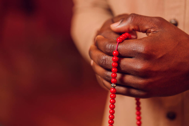 Hand holding a muslim beads rosary or tasbih on a praying mat, pray to god. Ramadhan Kareem. - Zdjęcie, obraz