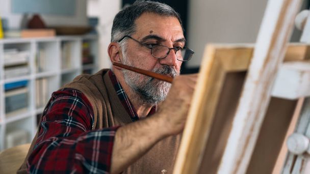 senior man painting the picture at his home - 写真・画像