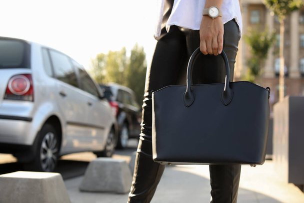 Young woman with stylish black bag on city street, closeup - Zdjęcie, obraz