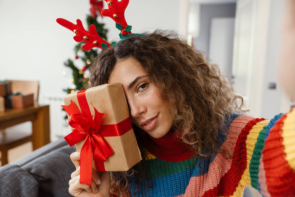 Nice caucasian charming woman taking selfie photo with gift box at cozy room - Zdjęcie, obraz