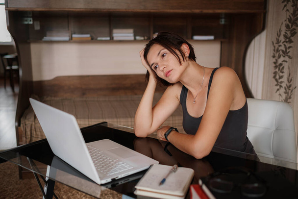Przemyślane wątpliwe azjatyckie uczennica pracownik patrząc daleko myśląc rozwiązywanie problemu czuć brak nowych kreatywnych pomysłów w pracy, zamyślone zagadkowe lub znudzona młoda kobieta siedzieć przy biurku z laptopem - Zdjęcie, obraz