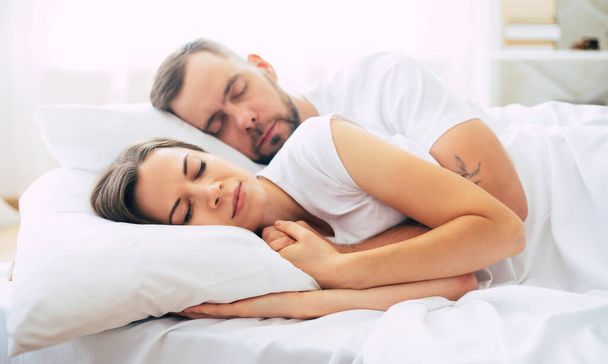 Beautiful tender young couple sleeping in big white bed and have good dreaming. - Fotoğraf, Görsel