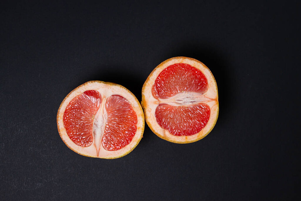 Grapefruit na černém pozadí. Grapefruit přeříznutý vejpůl. Citrusové plody. Exotické ovoce - Fotografie, Obrázek