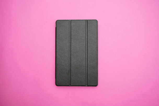 Tablet με μαύρη δερμάτινη θήκη σε ροζ φόντο - Φωτογραφία, εικόνα