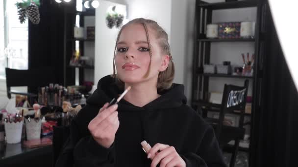Hermoso bloguero de cabello rubio aplica cosméticos. Mujer haciendo un video para su blog - Imágenes, Vídeo