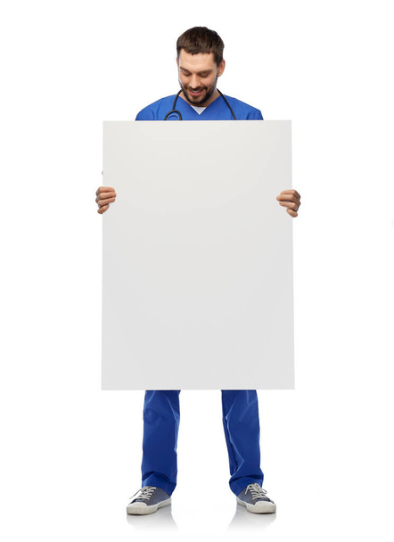 smiling male doctor or nurse with big white board - Foto, imagen