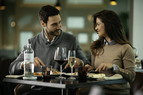 Feliz pareja amorosa disfrutando en el restaurante. Pareja joven disfrutando en la comida. - Foto, imagen