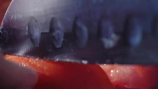 Corte hermoso tomate rojo con cuchillo de cocina, gotas de agua macro video. Tomate fresco húmedo y saludable para comer y cocinar en una granja ecológica - Imágenes, Vídeo