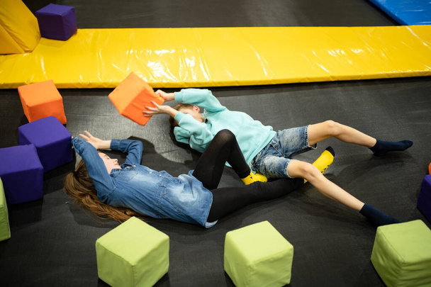 Active leisure. Children having fun on trampoline in entertainment center, childhood and sporty lifestyle. Boy and girl in leisure spotr center for kids. Brother and sister indulge on trampolines. - Photo, Image