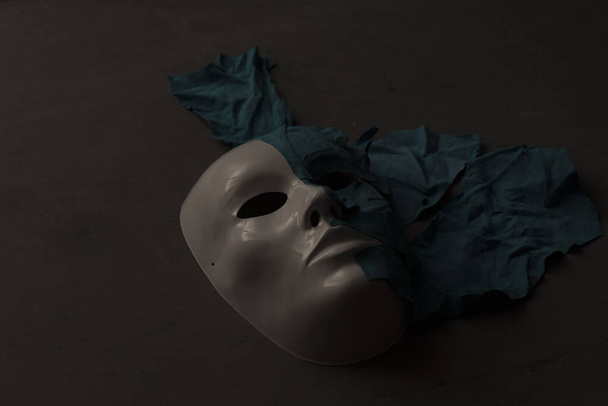 Máscara blanca sobre fondo negro cubierto de piel
 - Foto, imagen