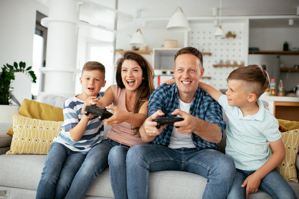  Щаслива закохана пара грає у відеоігри з дітьми вдома
. - Фото, зображення