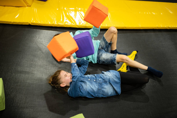 Children are active leisure. Sports weekend in sports center of acrobatics and trampoline. Physical education. Children having fun on trampoline in entertainment center, childhood and sporty lifestyle - 写真・画像