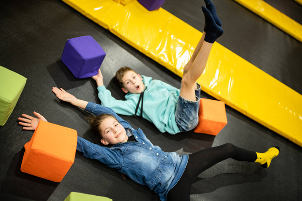 Children are active leisure. Sports weekend in sports center of acrobatics and trampoline. Physical education. Children having fun on trampoline in entertainment center, childhood and sporty lifestyle - Valokuva, kuva