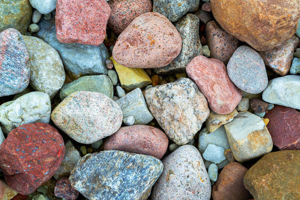 Azul, rosa, marrón, naranja, gris. Hermosas piedras marinas pequeñas. Primer plano de guijarros multicolores de colores en una playa. Naturaleza abstracta fondo, textura. - Foto, Imagen