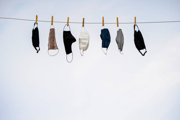 Waschbare Gesichtsschutzmasken trocknen auf dem Seil aus - Foto, Bild
