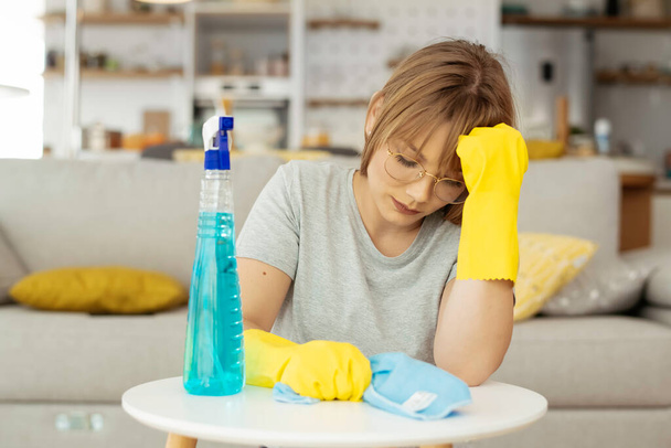 Sad woman cleaning home. Young tired woman at home. - Photo, Image