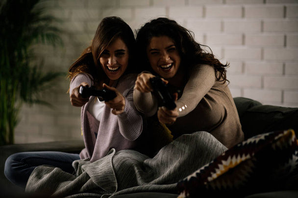 Mooie jonge vrouwen spelen videospelletjes thuis - Foto, afbeelding