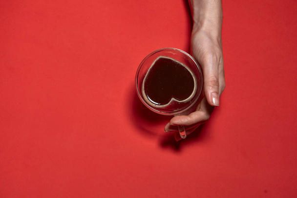 Día de San Valentín corazones fondo. Mujer sosteniendo taza caliente de café, con forma de corazón Stock Photo. Hermoso corazón decorativo en forma de fondo rojo, concepto de día de San Valentín - Foto, Imagen