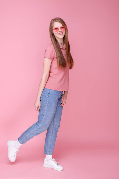 Girl walks and smiles on pink background - Photo, Image