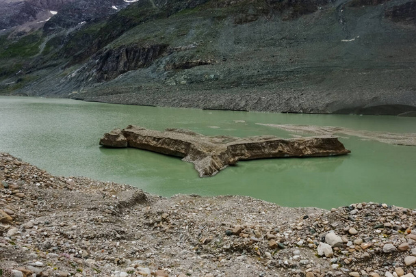 ハイキング中に山の湖からの緑の水の中の一つの島 - 写真・画像