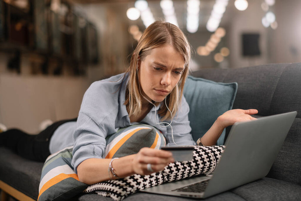 Een jonge vrouw met een creditcard en een laptop. Online winkelen concept - Foto, afbeelding