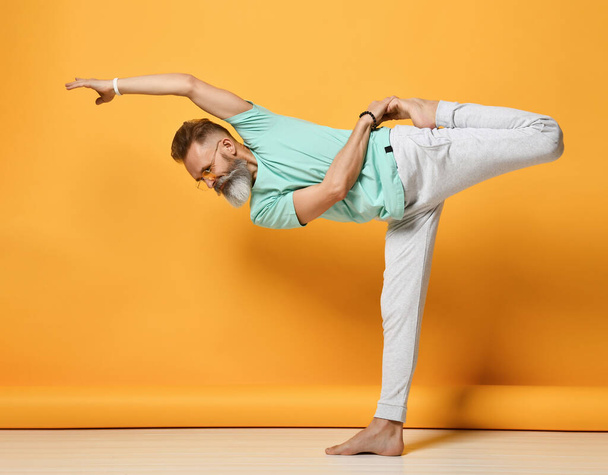 oga man. Man doing yoga on a yellow background - Fotoğraf, Görsel