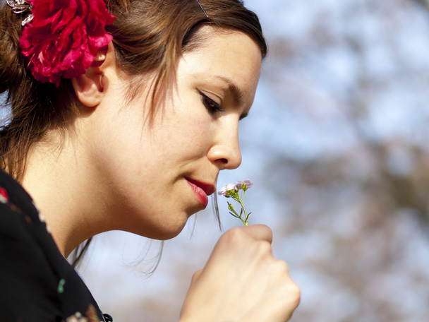 Hermosa chica oliendo una flor de cuco en la primavera
 - Foto, imagen