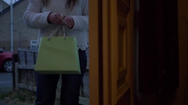 Mujer visita a casa y sostiene una bolsa de regalo - Metraje, vídeo