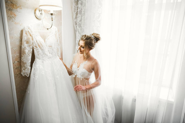 Luxury bride in white dress posing while preparing for the wedding ceremony - Foto, Imagen