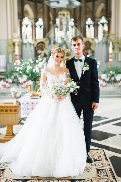 Married couple posing in a church after ceremony - Фото, зображення