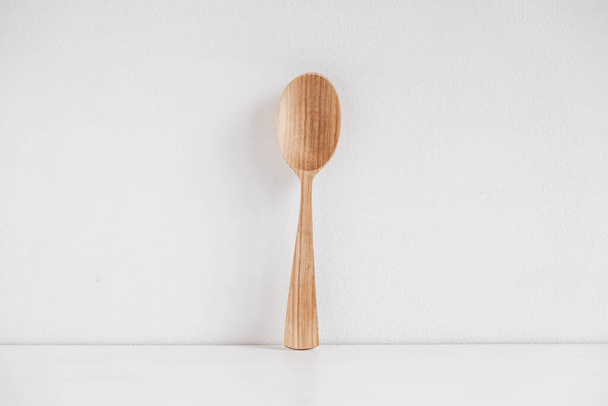 Empty wooden spoon on a white table background. Copy, empty space for text. - Fotografie, Obrázek
