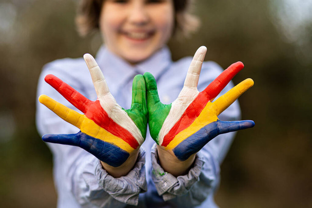 Freedom Seychelles concept. Cute child forming flying bird gesture with hands painted in Seychelles flag colors - 写真・画像